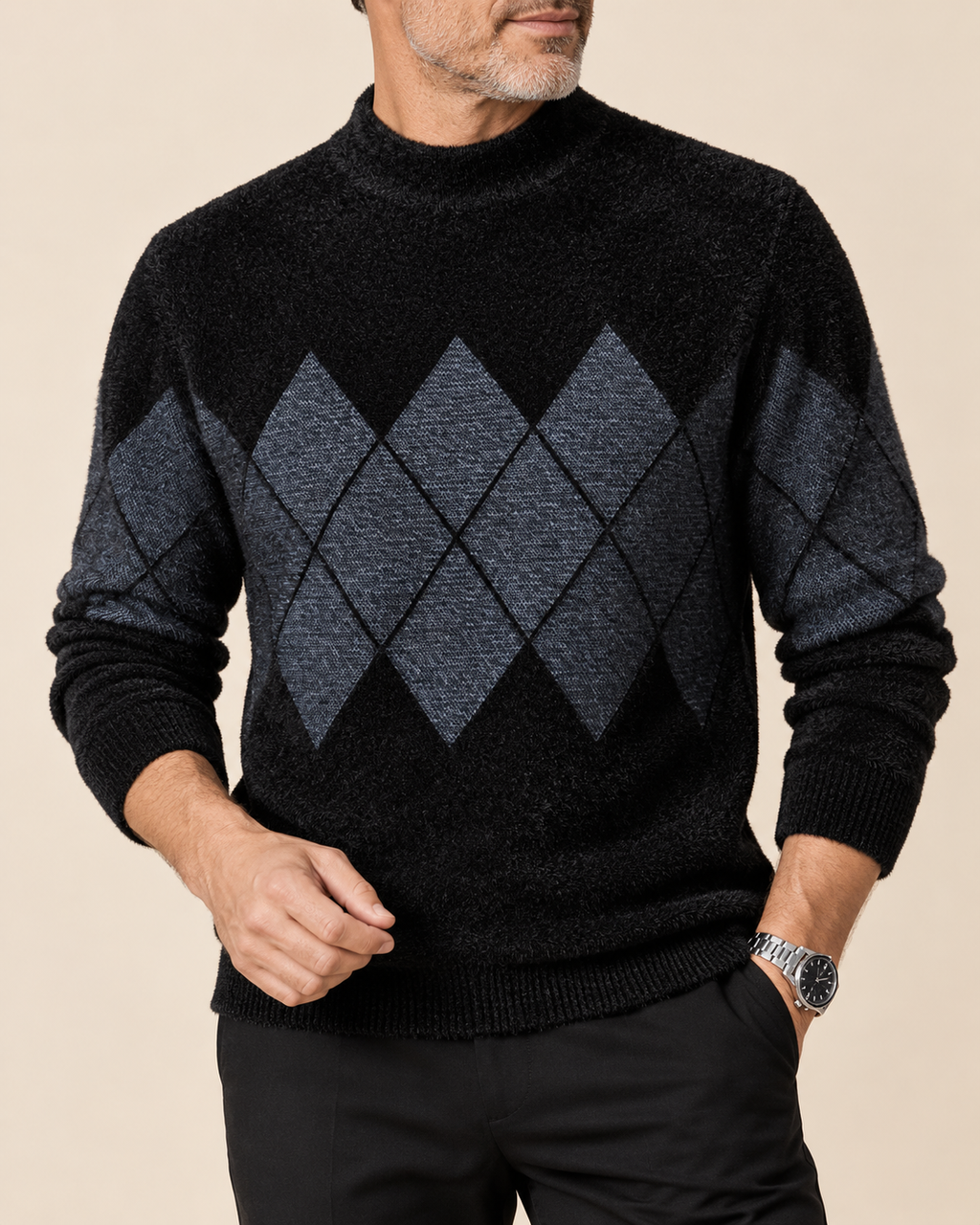 A man wearing a black mock-neck knit sweater with a dark gray argyle pattern on the chest and sleeves, paired with black trousers, against a solid beige background.