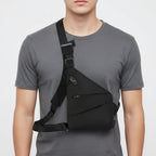 Person wearing a black shoulder bag on a plain background